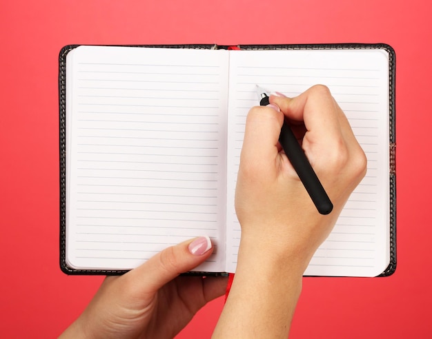 Mão escrever no notebook na cor de fundo