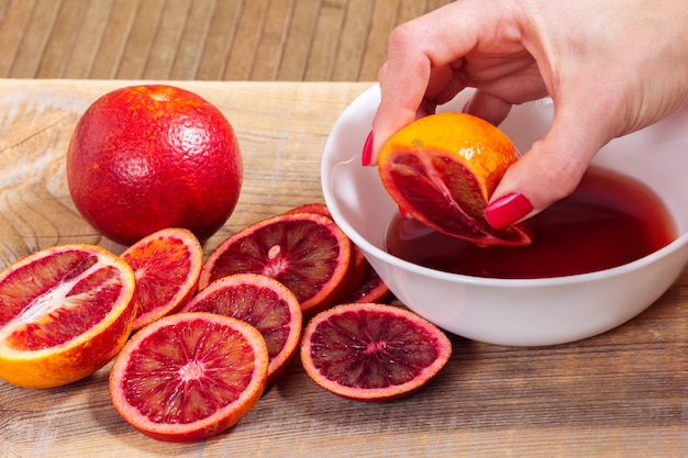 mão espreme suco de laranja siciliano