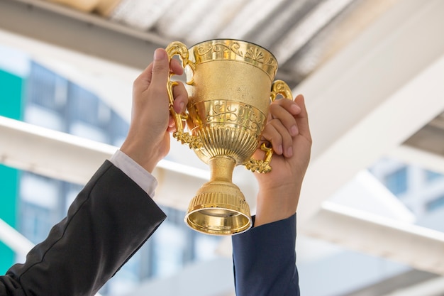 Foto mão está segurando a taça de ouro