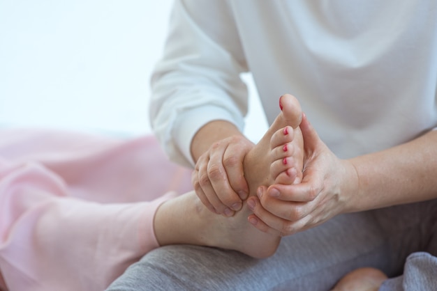 Mão fazendo massagem tailandesa nos pés Medicina alternativa relaxa bem-estar e conceito de massagem tailandesa