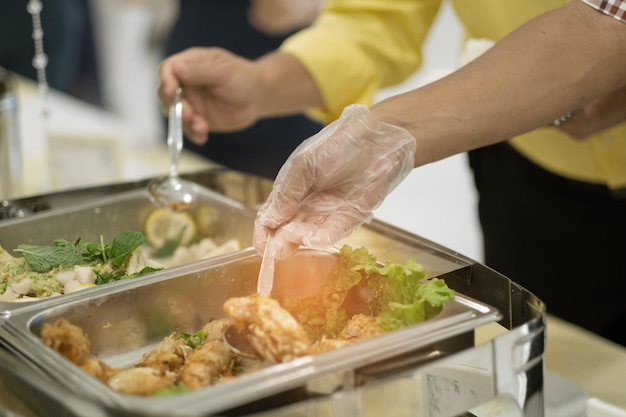 Mão fechada usando luvas para colher comida na hora do jantar previne a doença de Coronavirus covid 19xAxA