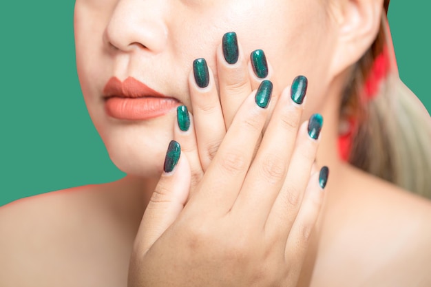 Mão feminina com design de unha verde sobre fundo verde Manicure de mulher é arte lindo estilo de verão Closeup de dedos de beleza de jovem saudável