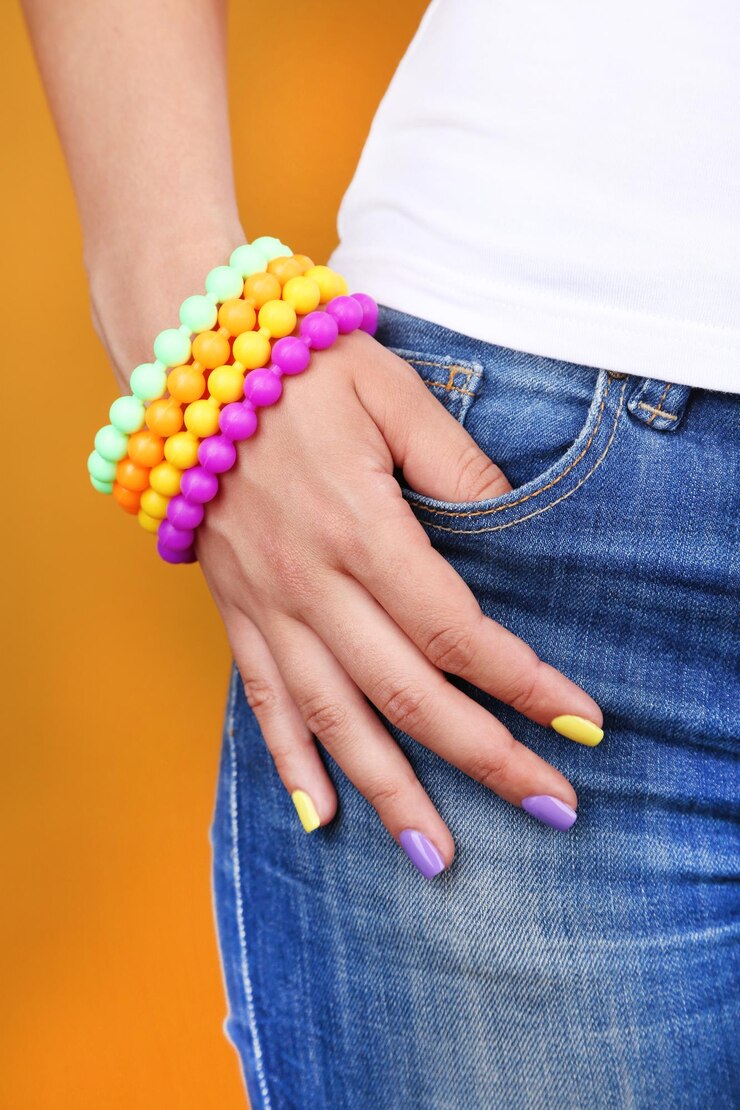 Foto mão feminina com elegantes unhas coloridas fechadas sobre fundo colorido