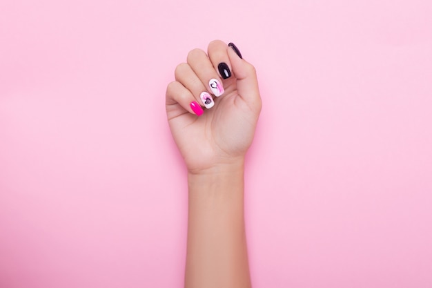 Mão feminina com unhas de manicure criativas