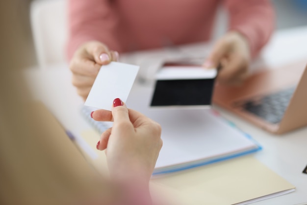 Mão feminina dá cartão de chamada em branco visitante de colarinho branco troca de nome de empresa e