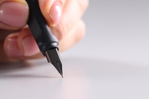 Mão feminina escrevendo caneta-tinteiro preta close-up