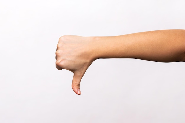 Mão feminina mostrando o gesto do polegar para baixo isolado em um fundo branco Sinal negativo Dedo para baixo