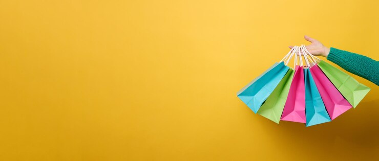 Foto mão feminina segura um saco descartável de papel com alças para mantimentos e roupas. embalagem reciclável. desperdício zero. banner de venda