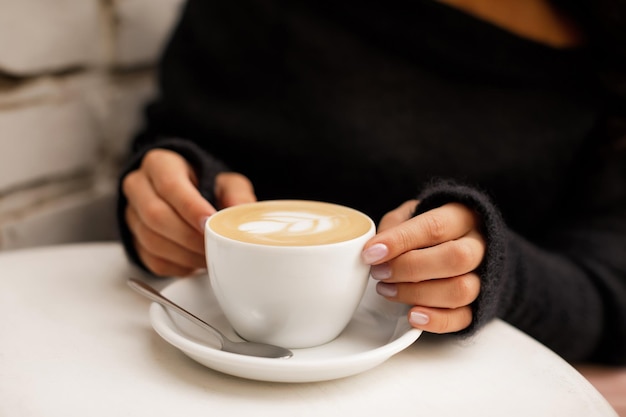 Mão feminina segura xícara de café quente