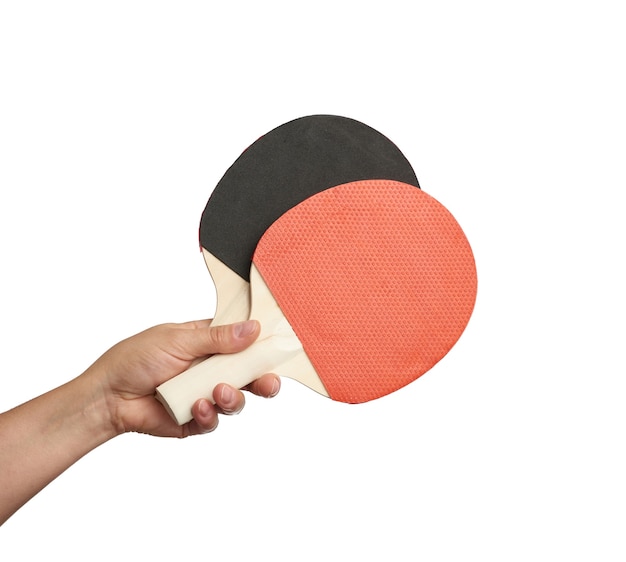 Mão feminina segurando duas raquetes de tênis de mesa de madeira