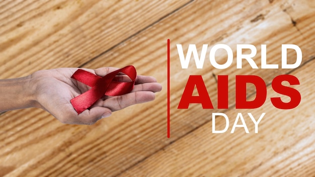 Mão humana mostrando o conceito do Dia Mundial da Aids para conscientização da fita vermelha