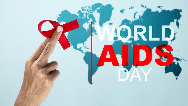 Mão humana mostrando o conceito do Dia Mundial da Aids para conscientização da fita vermelha