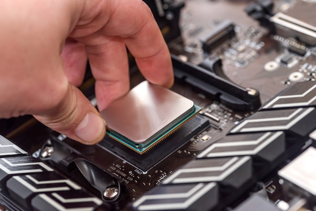 Mão humana retirando cpu da placa-mãe