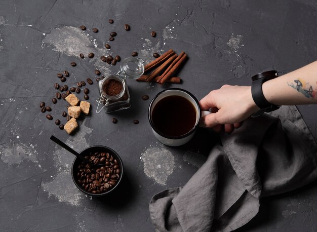 Mão leve xícara de café fundo escuro feijão vista superior café expresso canela