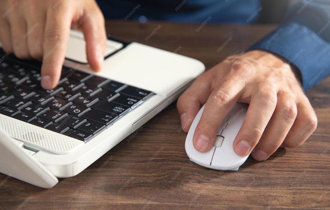 M o masculina clicando no mouse do computador e digitando no teclado do