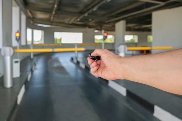 Mão masculina com controle remoto de uma barreira automática