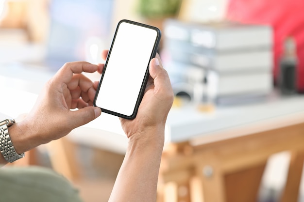 Mão masculina de tiro cortada segurando o telefone móvel de tela em branco