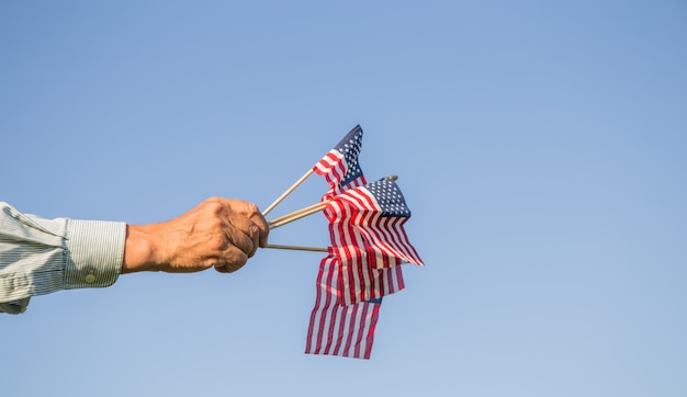 Mão masculina segurando a bandeira americana