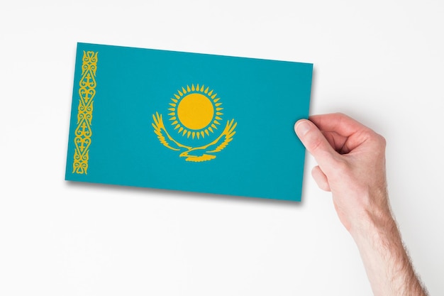 Mão masculina segurando a bandeira do cazaquistão