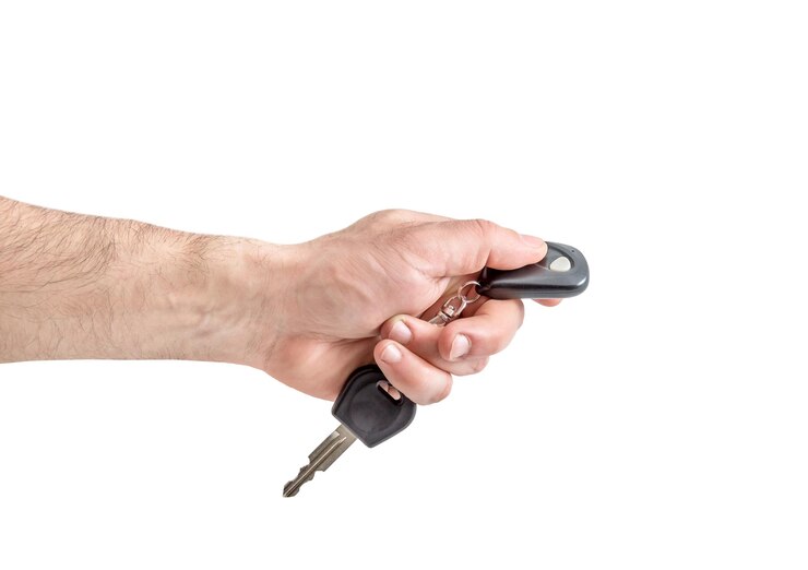 Foto mão masculina segurando a chave do carro com controle remoto isolado no branco
