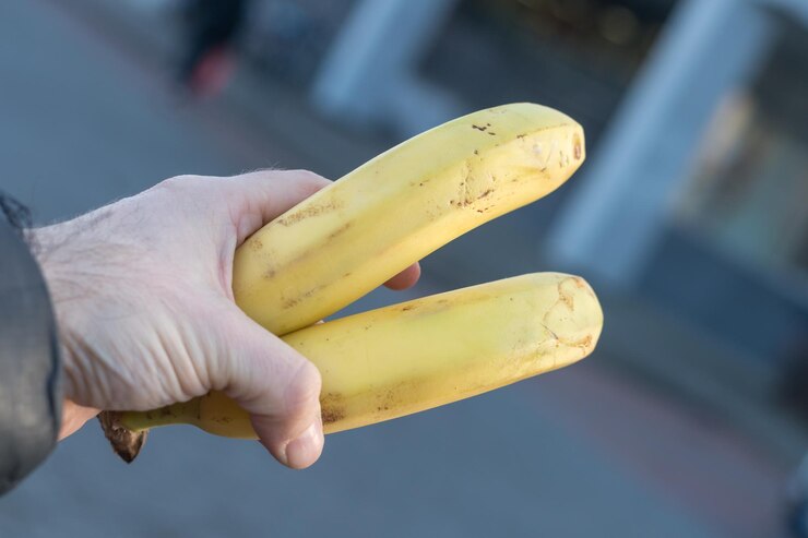 Foto mão masculina segurando duas bananas