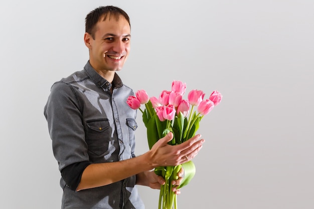 Mão masculina segurando lindas tulipas em fundo branco