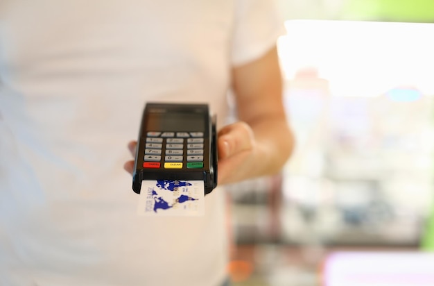 Foto mão masculina segurando o terminal pos com cartão de crédito closeup