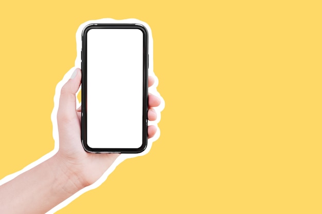 Mão masculina segurando um smartphone com tela em branco isolada em fundo amarelo