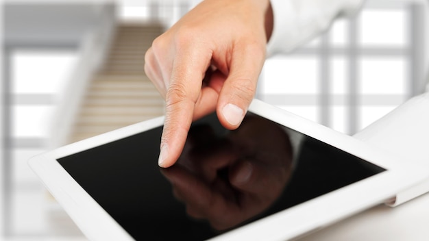 Mão masculina segurando um tablet PC na mesa