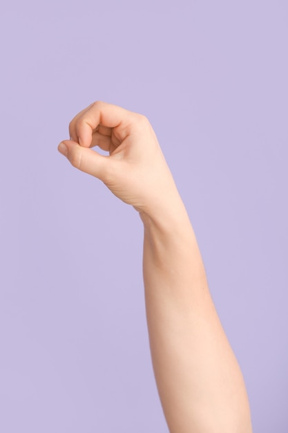 Mão mostrando a letra O em lilás. Alfabeto de linguagem de sinais