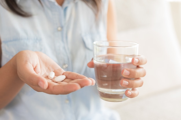 Mão mulher, com, pílulas, medicina, tabuletas, e, vidro água, para, dor de cabeça, tratamento