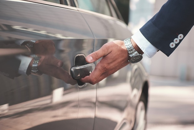 Mão na alça, close-up da mão do homem abrindo a porta do carro