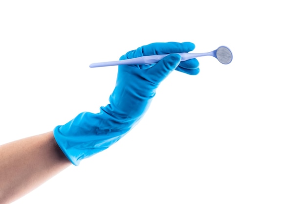 Mão na luva azul segurando um espelho dental em ângulo isolado no fundo branco