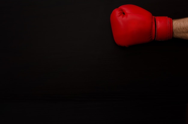 Foto mão na luva de boxe vermelha no escuro