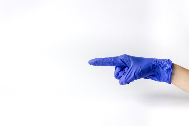 Mão na luva médica com o dedo apontando para o lado em um fundo branco. Um espaço para texto.