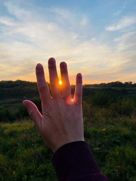 mão no fundo do pôr do sol