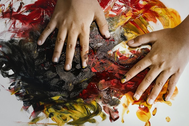 Foto mão recortada de criança pintando em papel