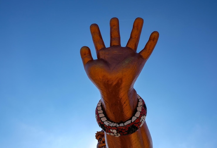 Foto mão recortada de estátua contra o céu azul