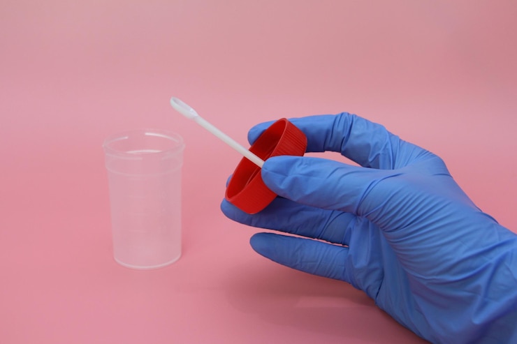 Foto mão recortada de médico segurando garrafa contra fundo rosa
