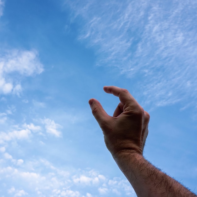 Foto mão recortada de pessoa contra o céu