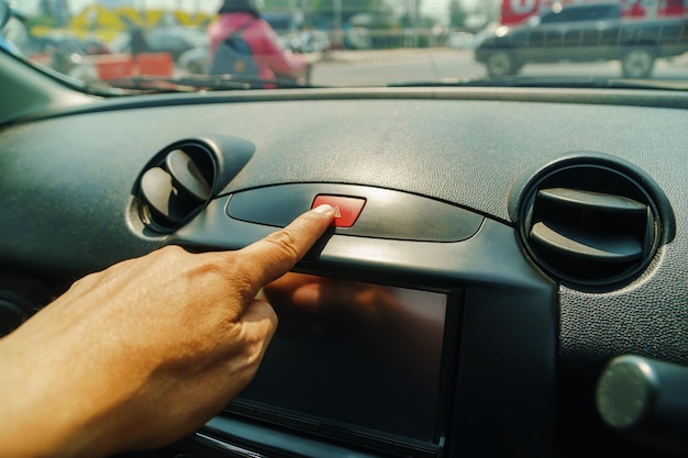 Foto mão recortada de pessoa pressionando o botão no carro