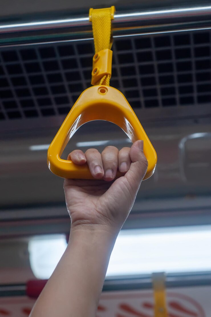 Foto mão recortada de pessoa segurando o trilho da mão do trem de passageiros