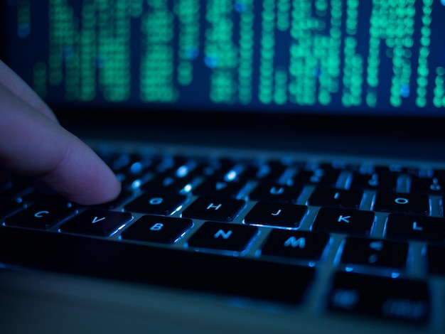 Mão recortada de um hacker de computador a digitar no teclado