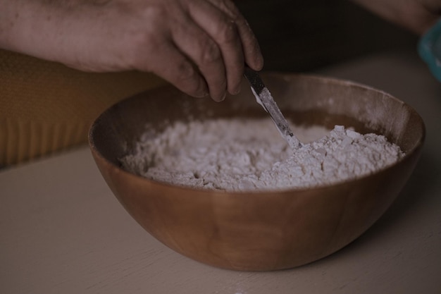 Mão recortada mexendo comida em uma tigela