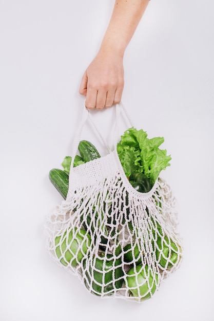 Mão segura eco bag malha legumes frutas