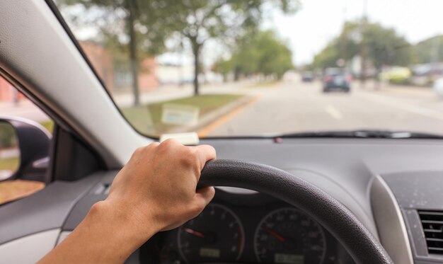 Foto mão segura o volante de um carro, simbolizando uma direção segura e controlada, com foco na responsabilidade