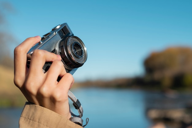 Mão segurando a câmera fotográfica