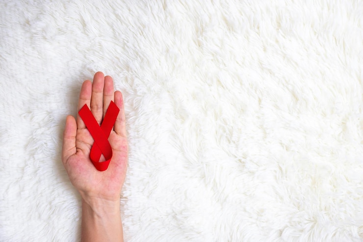 Foto mão segurando a fita vermelha para apoiar as pessoas que vivem e doenças. conceito de saúde e sexo seguro. dezembro dia mundial da aids e mês da conscientização sobre o câncer do mieloma múltiplo