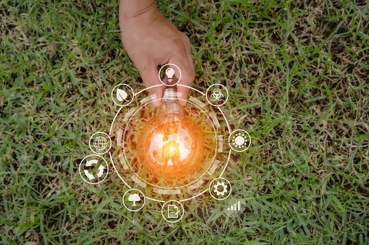 Foto mão segurando a lâmpada na natureza sobre fundo verde para o conceito de energia
