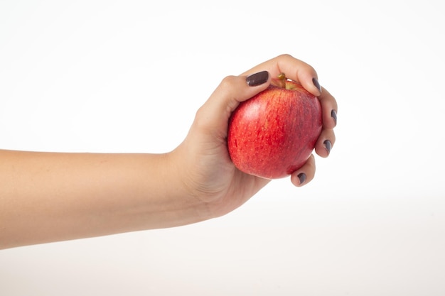 Mão segurando a maçã vermelha inteira isolada no fundo branco